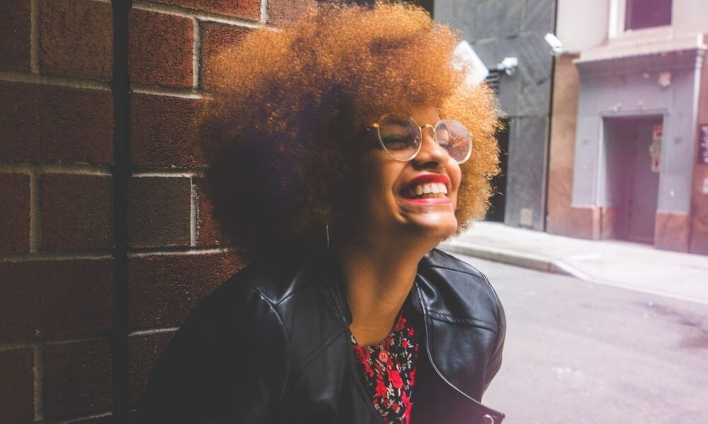 Schwarze Frau mit Brille lächelt
